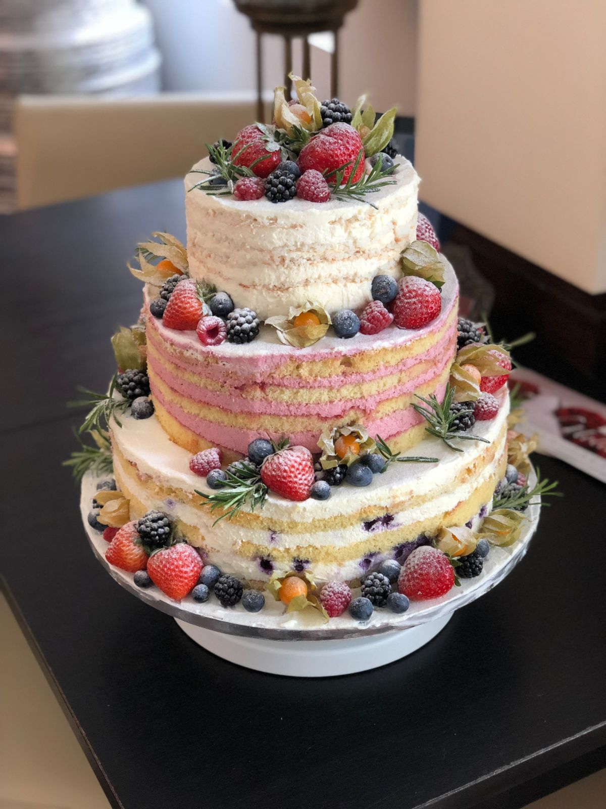 Dreistöckiger Naked Cake mit rosa Mittellage und frischen Beeren