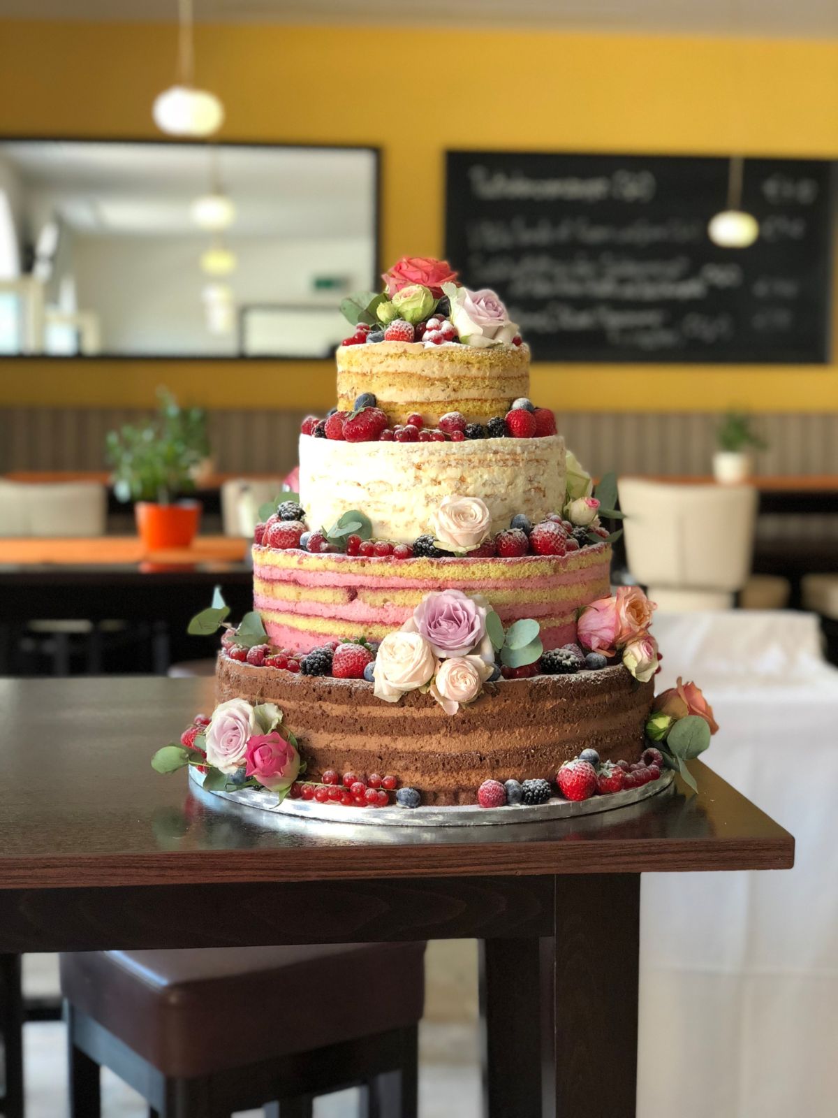 Vierstöckiger Naked Cake mit braunen und rosa Schichten