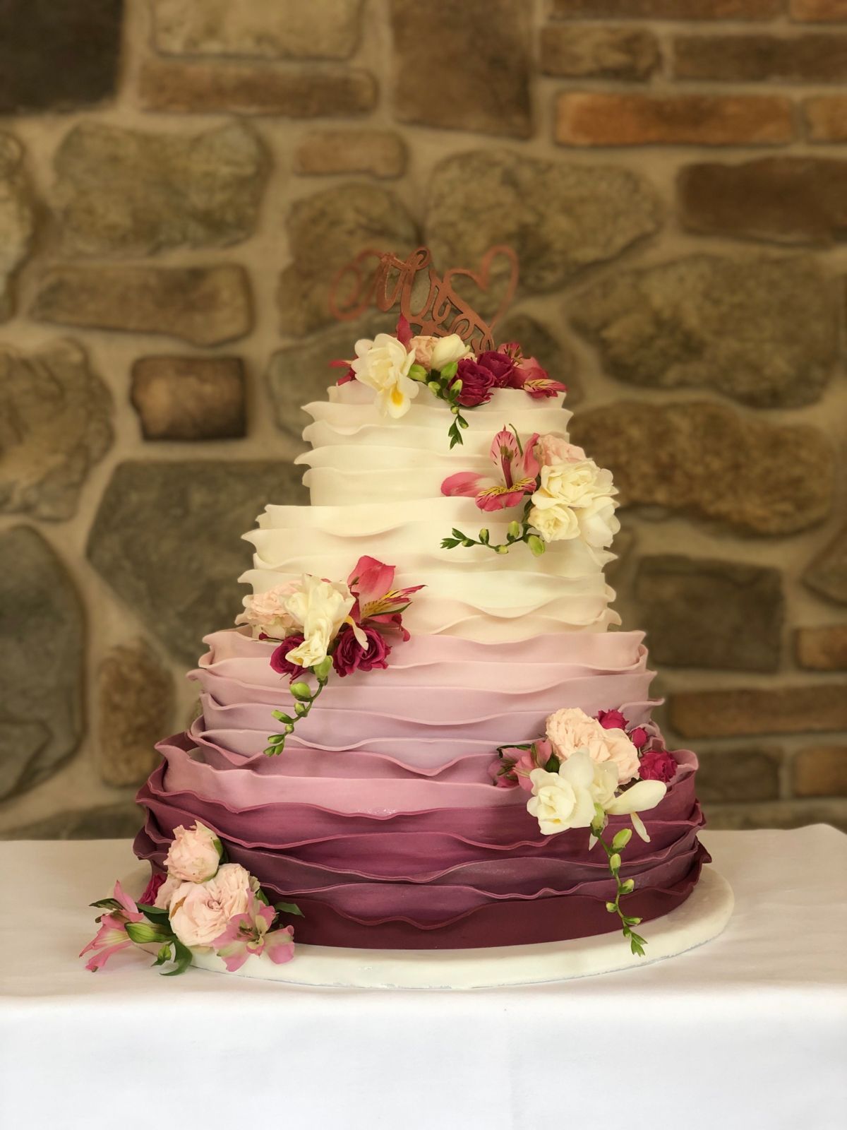 Vierstöckige Hochzeitstorte mit gerüschtem Ombré-Fondant von Weiß zu Burgunderrot und weißen Pfingstrosen