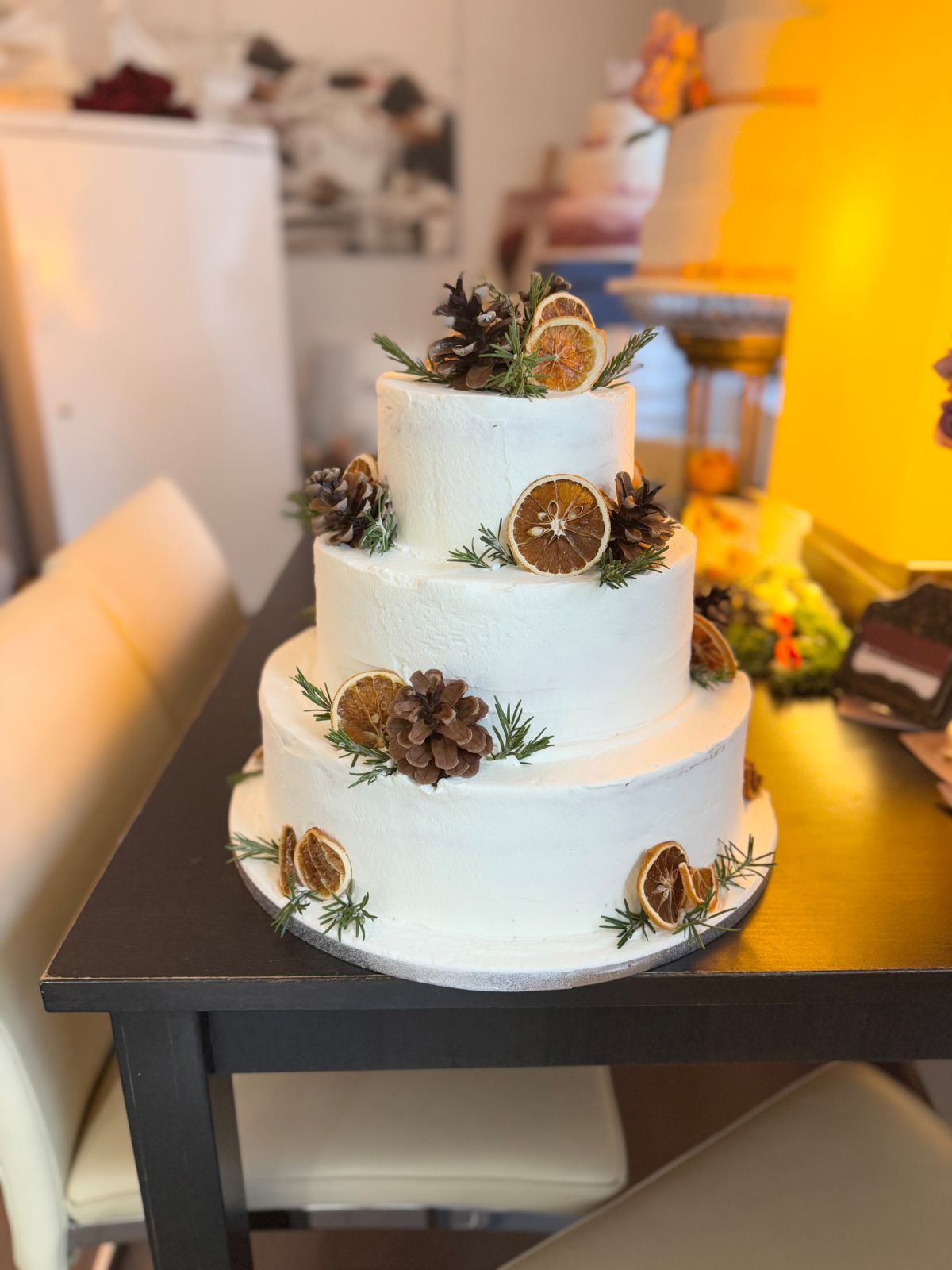 Dreistöckige Hochzeitstorte mit Zapfen, getrockneten Orangenscheiben und Rosmarin