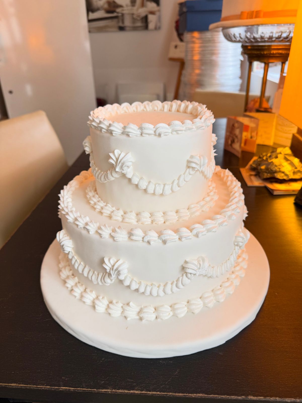 Zweistöckige Hochzeitstorte in Weiß mit gespritzten Girlanden im Vintage-Stil