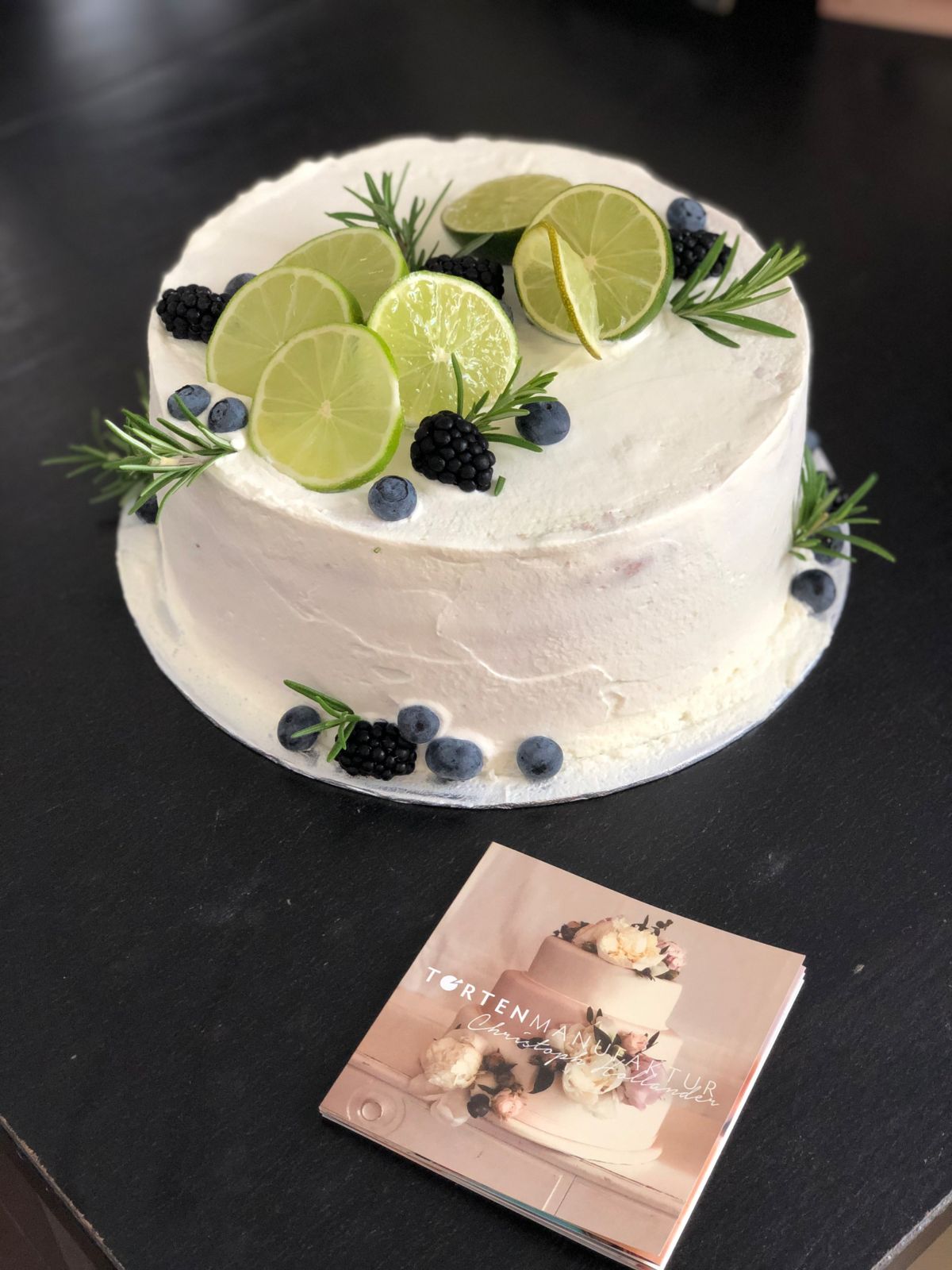 Einstöckige Torte mit Limettenscheiben, Brombeeren, Heidelbeeren und Rosmarin