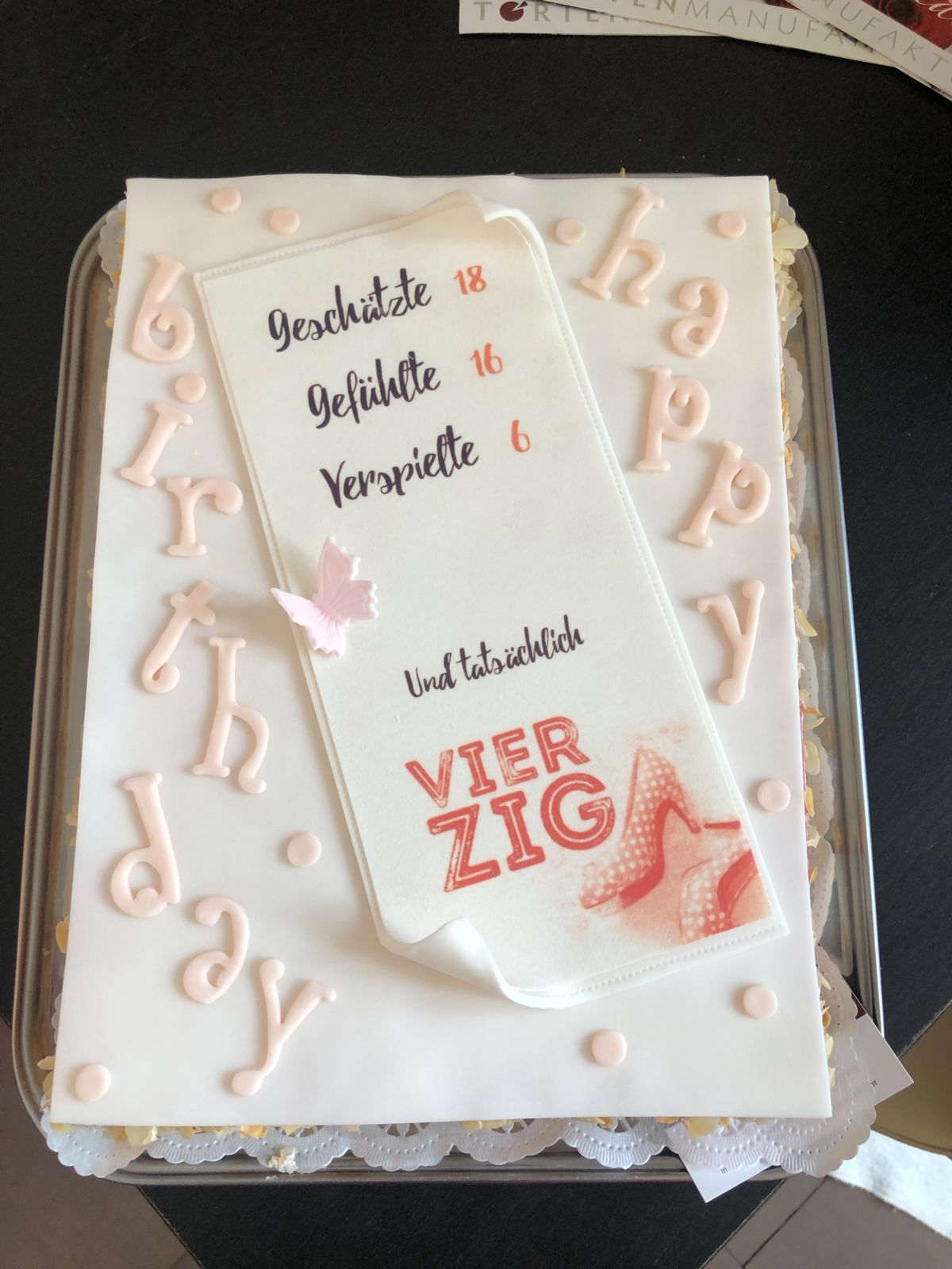Rechteckige Torte mit weißem Fondant und Namenstafel mit Altersangaben