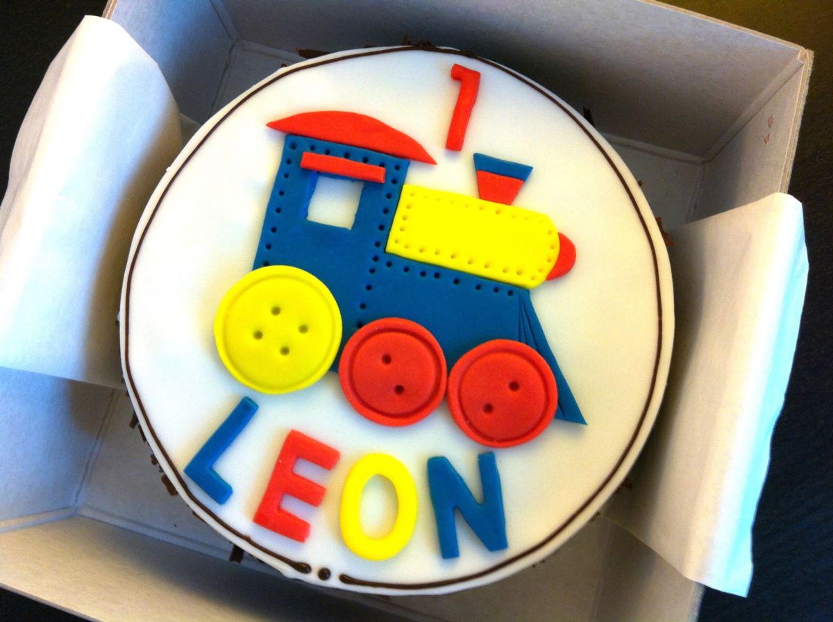 Kindergeburtstagstorte als bunte Lokomotive mit blau-gelbem Design