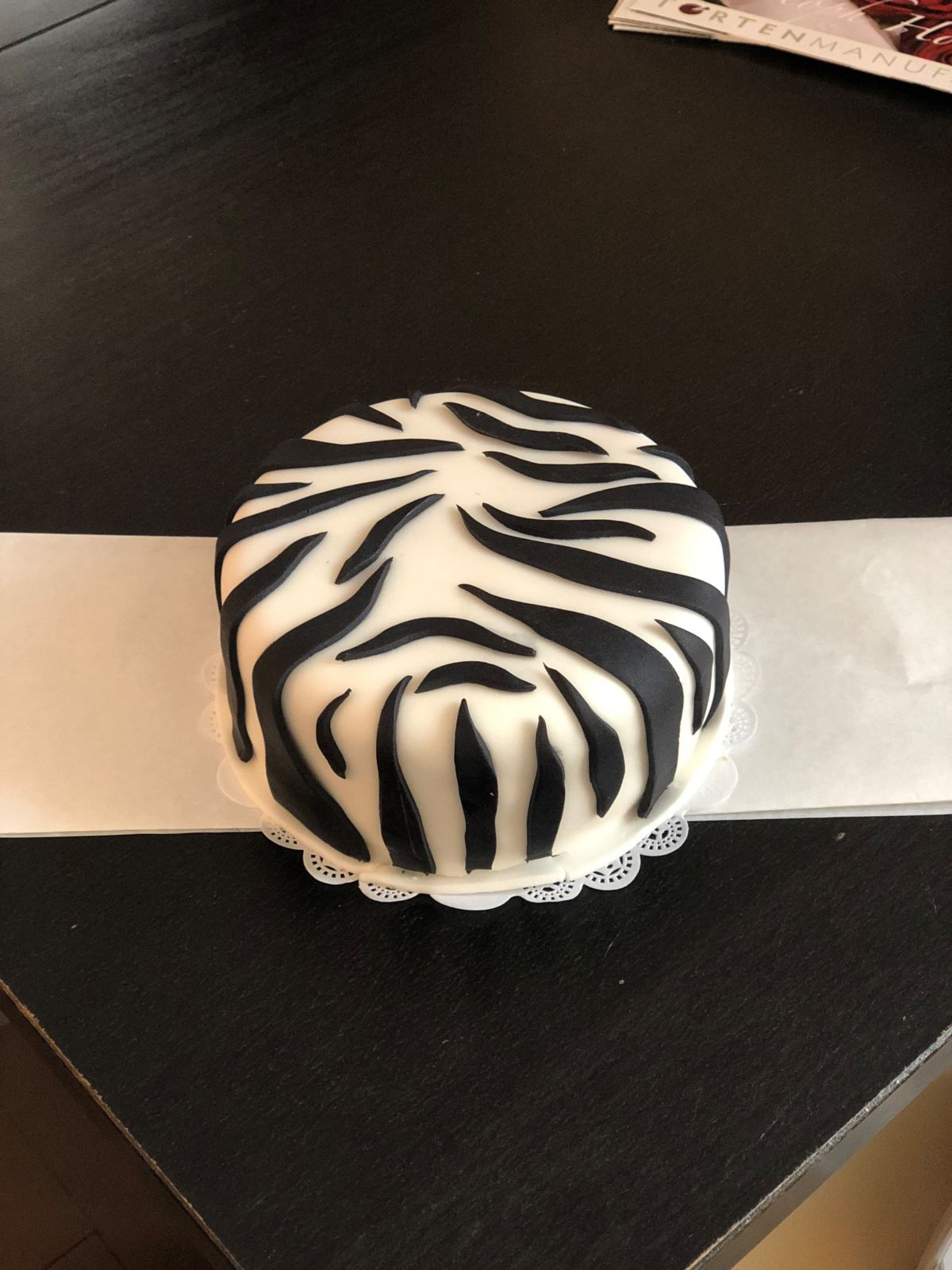 Runde Torte mit weißem Fondant und Zebra-Streifenmuster