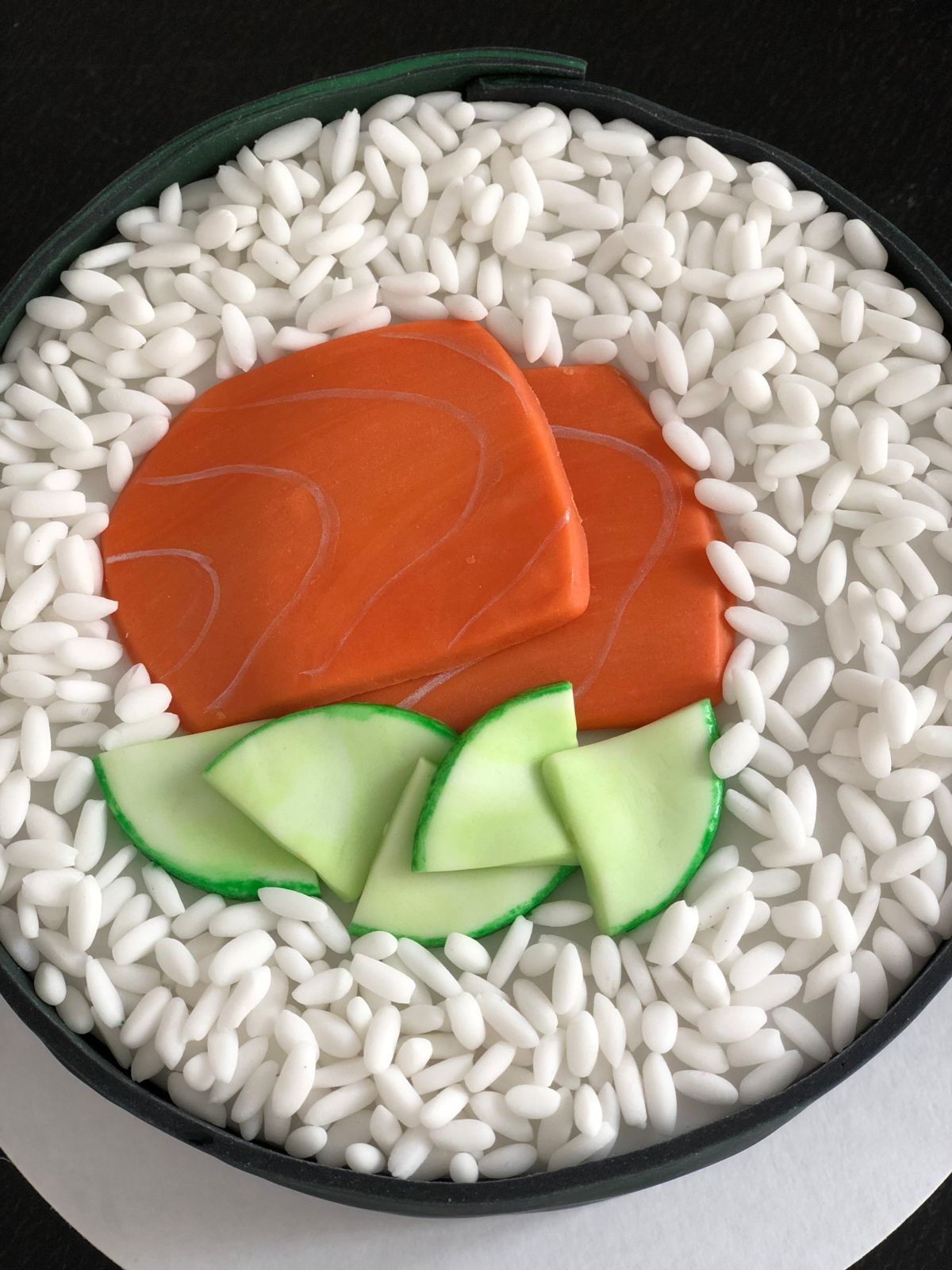 Runde Torte mit weißer Bordüre, roter Fondant-Rose und grünen Blättern
