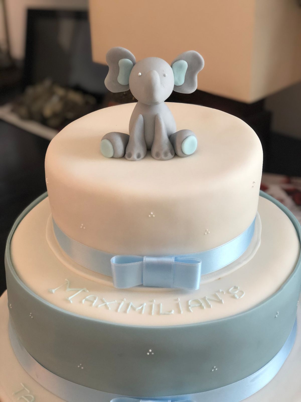 Zweistöckige helle Tauftorte mit grauem Elefanten oben