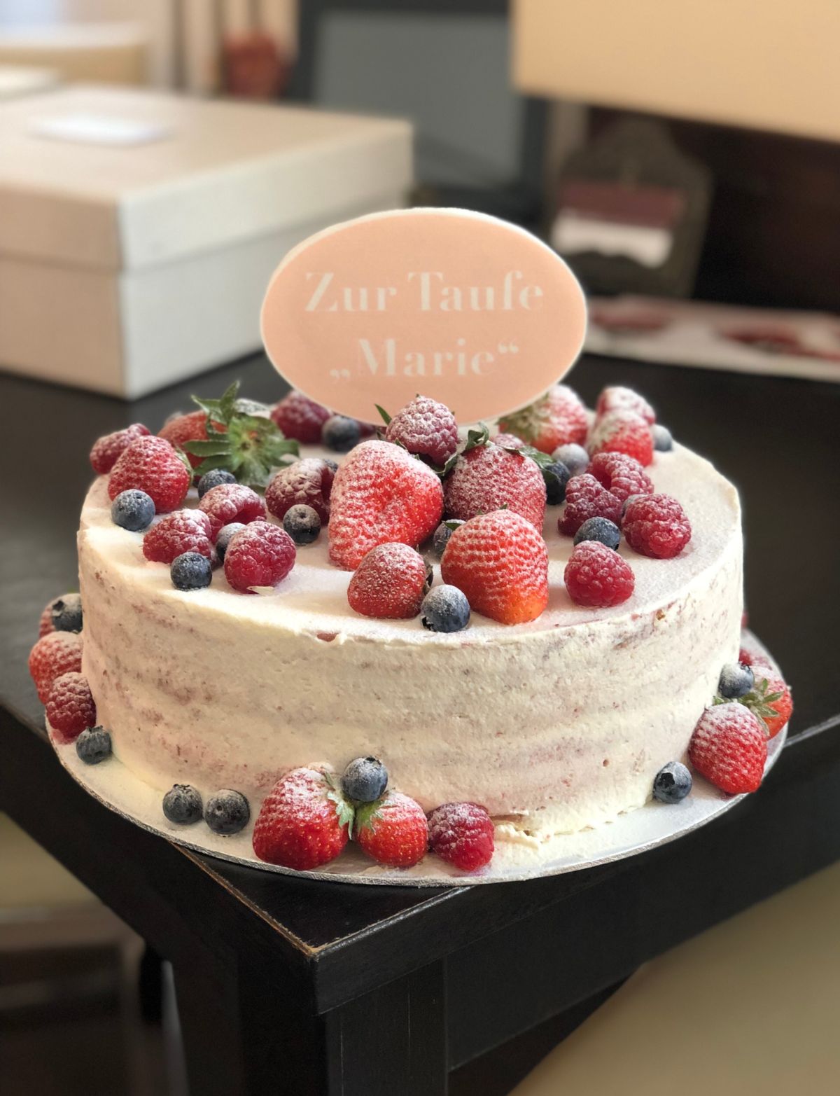 Zweistöckige Naked-Cake-Tauftorte mit Himbeeren und Blaubeeren