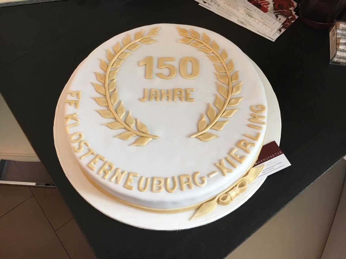 Runde Jubiläumstorte zum 150-jährigen Bestehen mit Lorbeerkranz, goldenen Verzierungen und Text