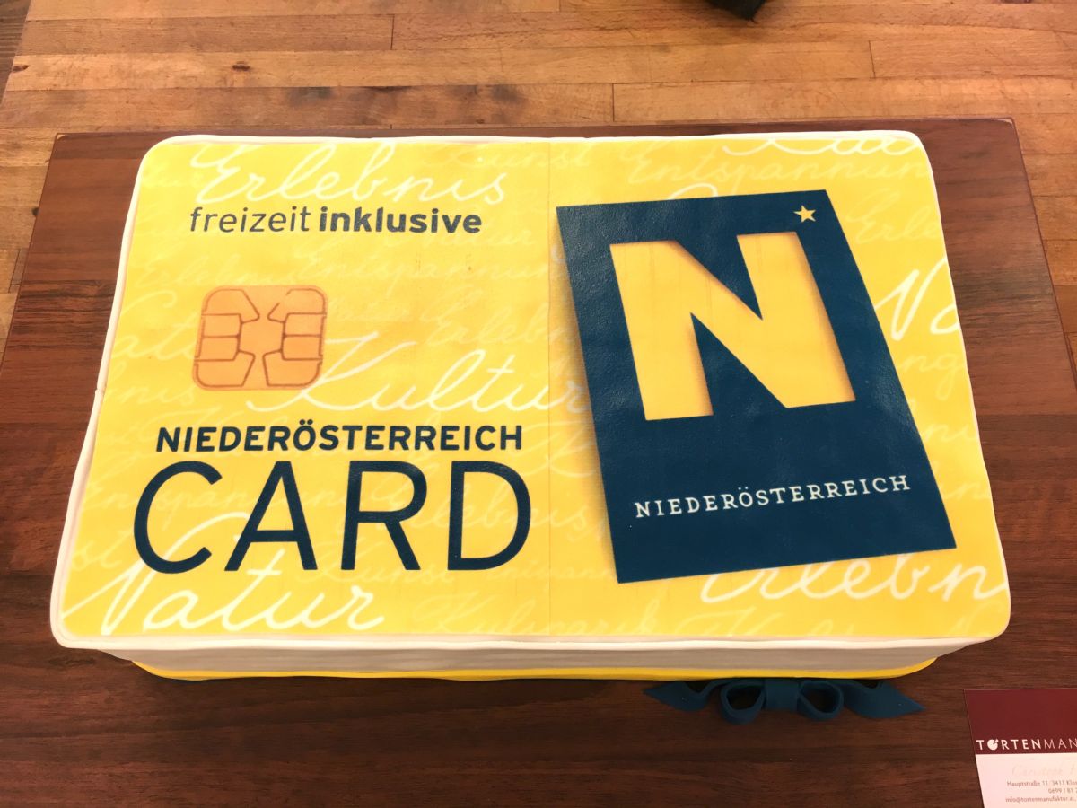 Kartenmotiv-Torte in Gelb als Niederösterreich Card mit Chip-Detail und „freizeit inklusive“