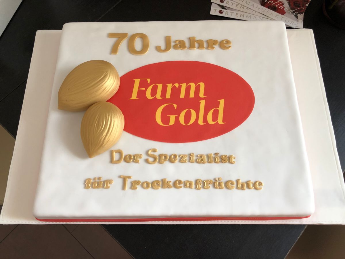 Quadratische Firmentorte zum 70-jährigen Bestehen von Farm Gold mit Nussdekor und rotem Oval-Logo