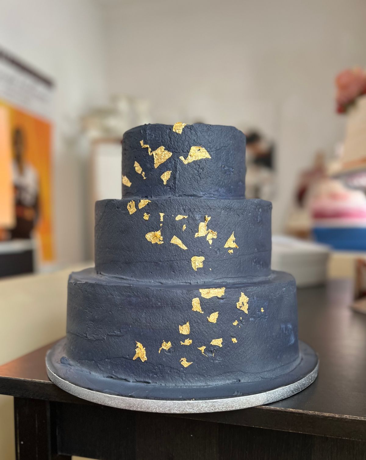 Three-tier charcoal wedding cake with gold leaf