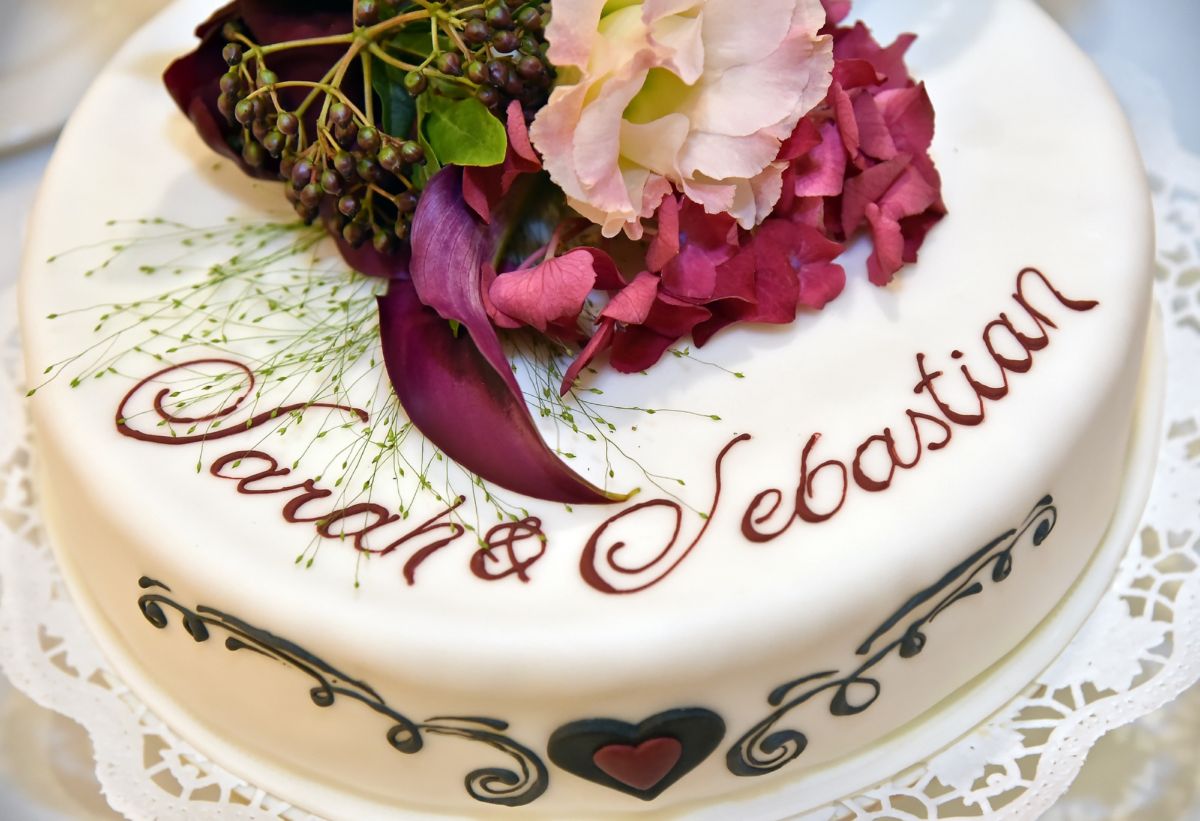 Five-tier wedding cake with ribbed texture, pink roses and decorative lettering