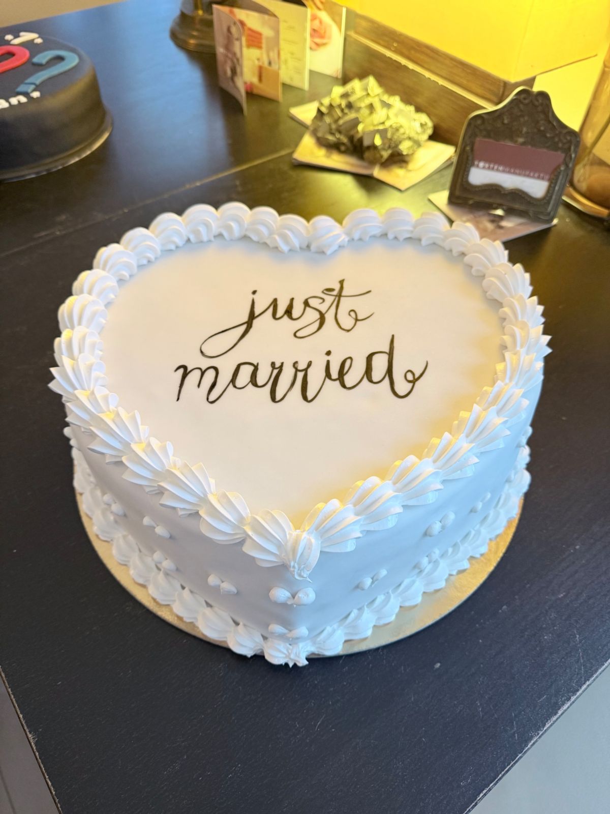 Heart-shaped cake with “just married” lettering and a piped border
