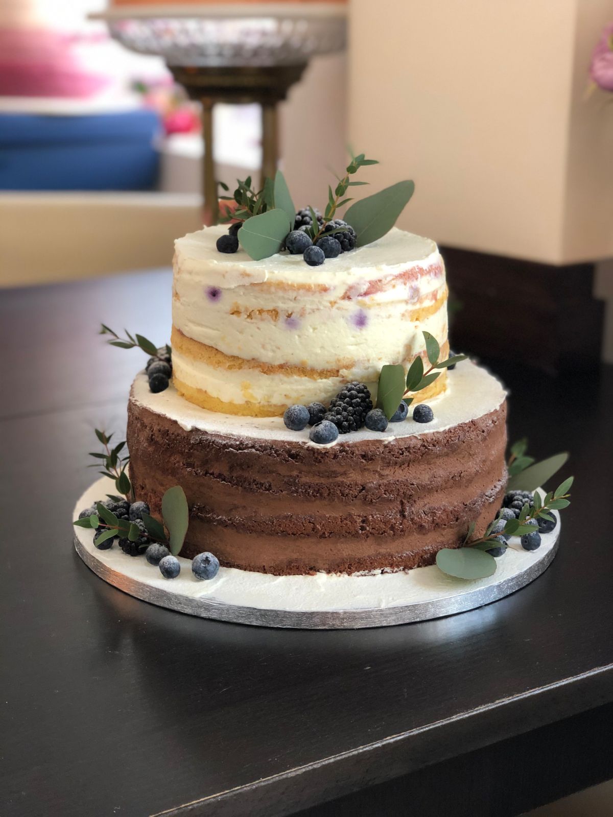 Two-tier naked cake with a dark chocolate lower tier, blueberries and blackberries