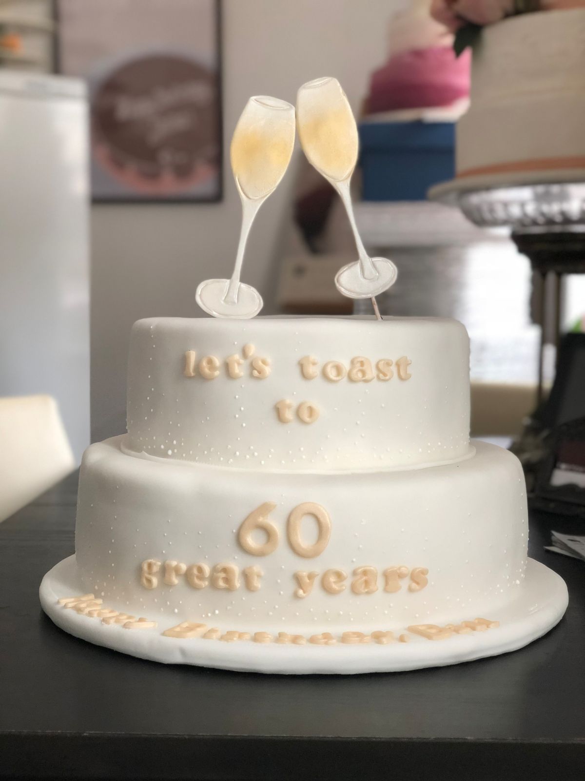 Two-tier white birthday cake with champagne flute topper