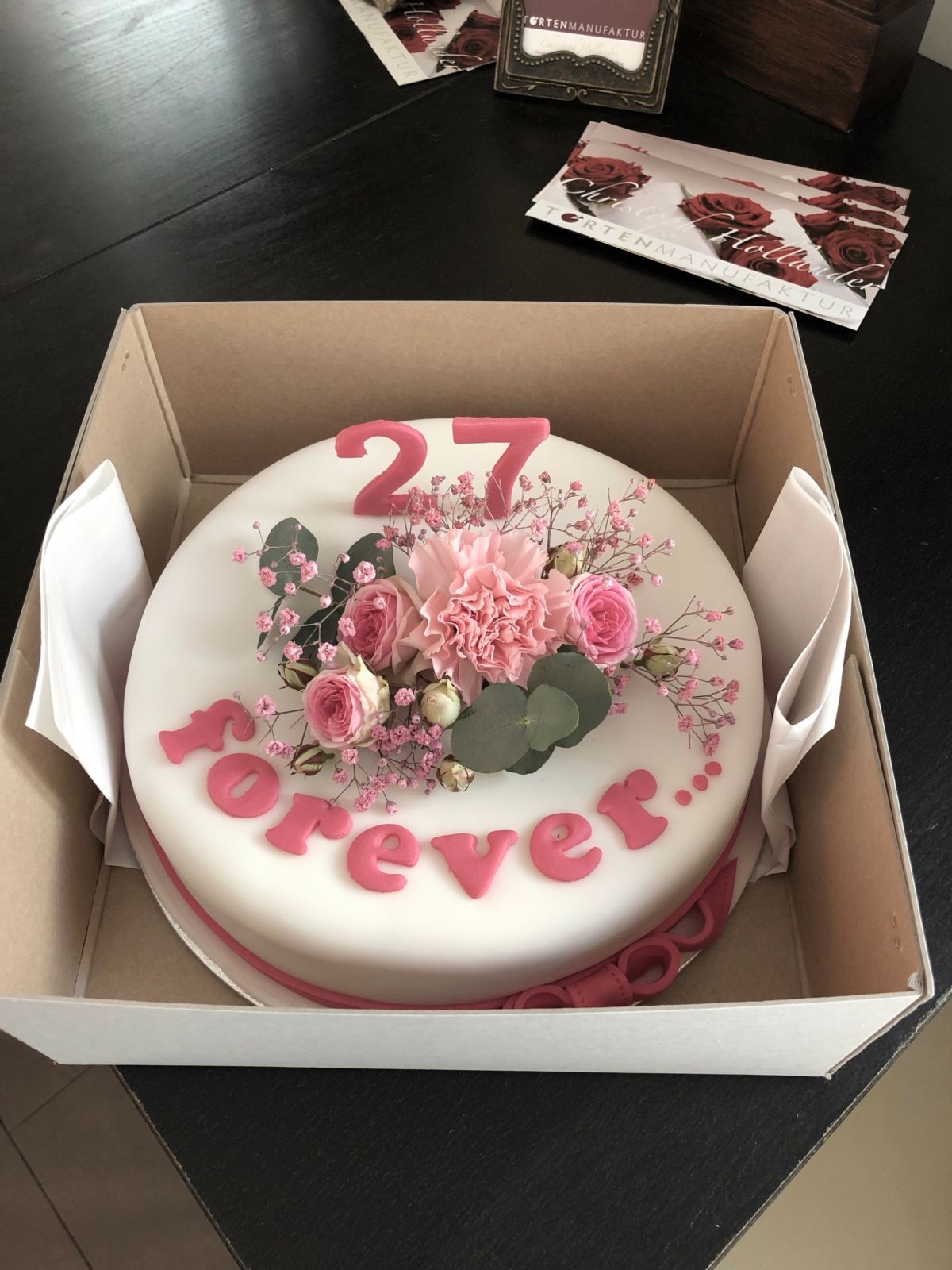 Round cake with fresh pink roses and carnations for age 27