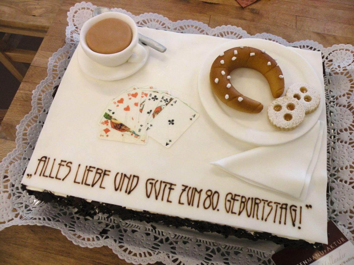 80th birthday cake with coffee cup, playing cards, pretzel, and pastry decorations