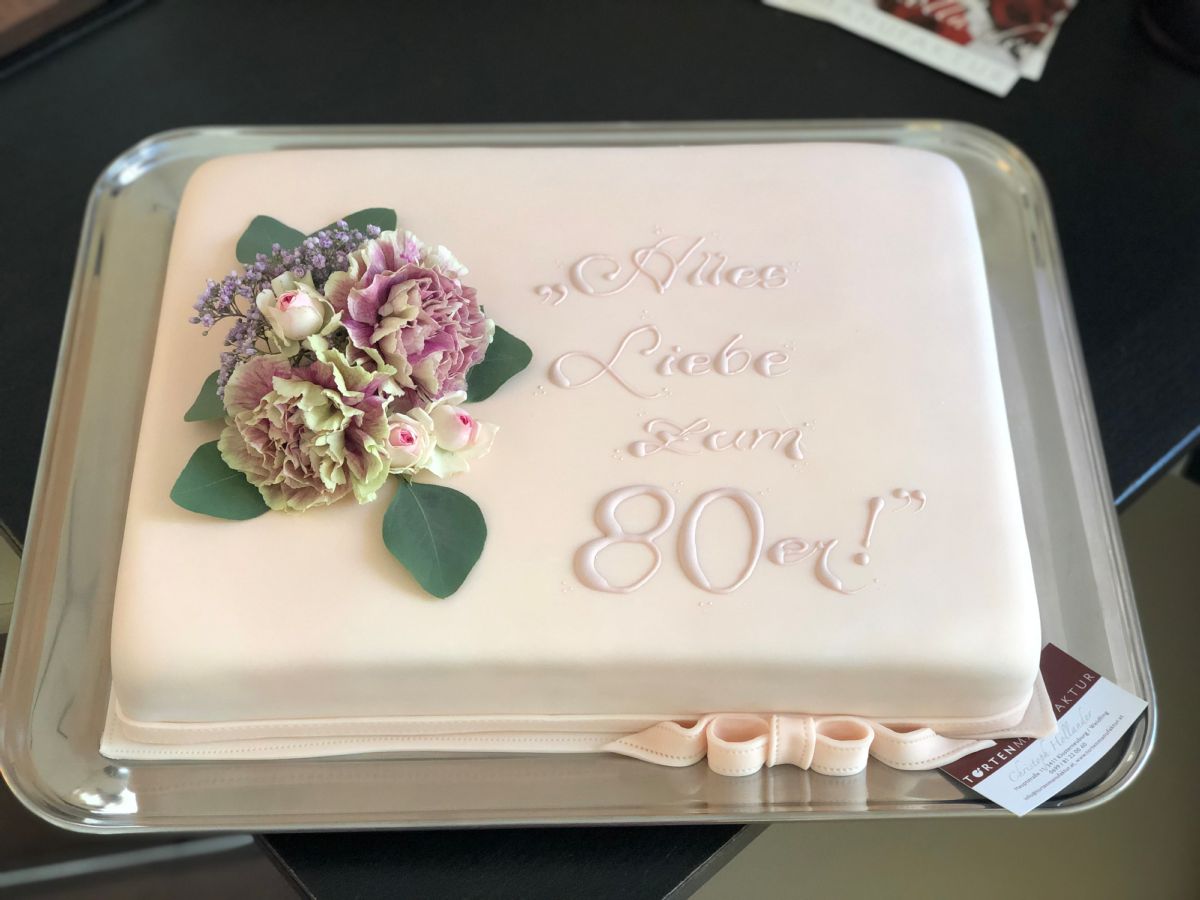 Rectangular cake for 80th birthday decorated with fresh pink and purple carnations
