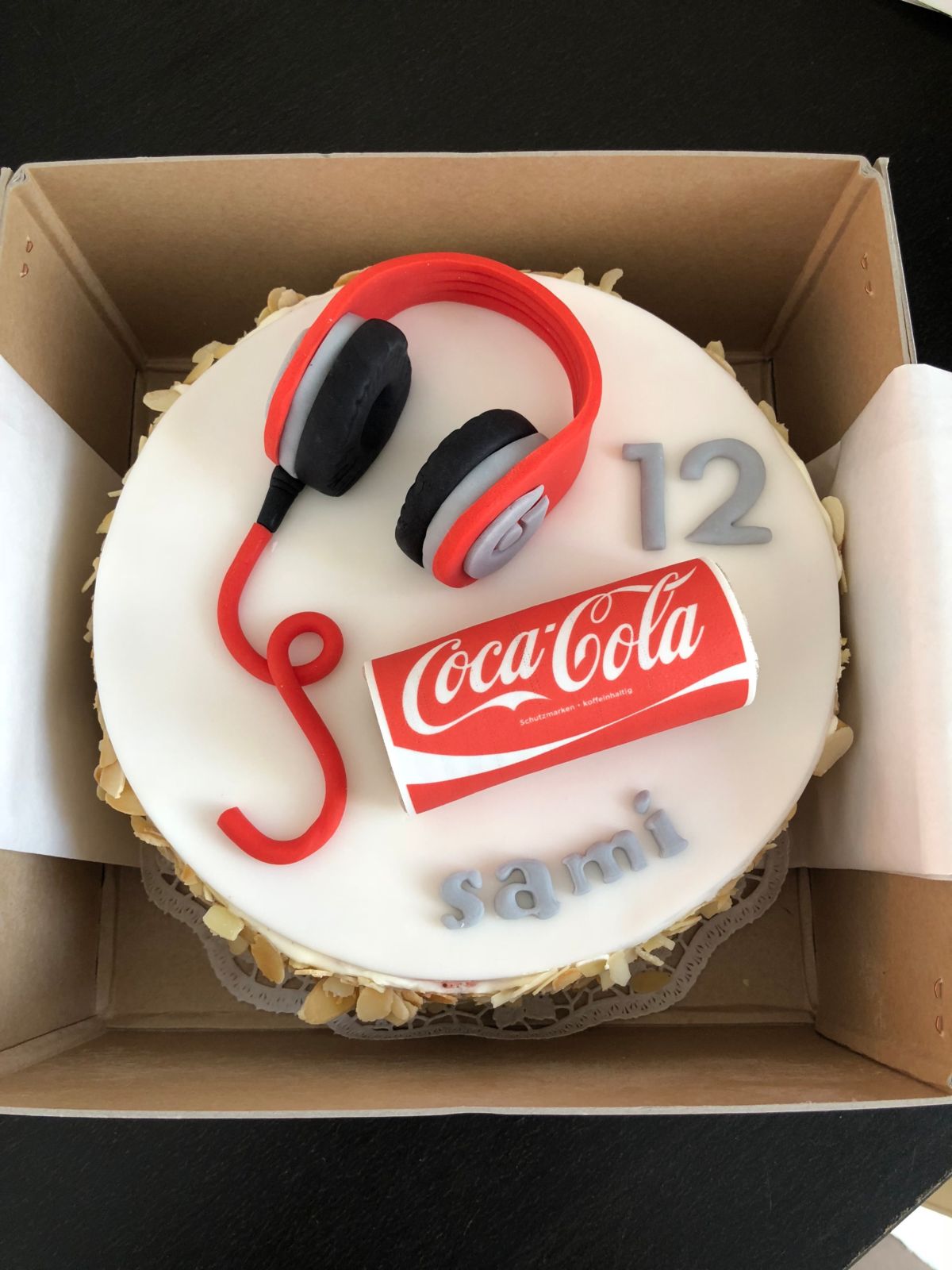 Children’s birthday cake decorated with red headphones and Coca-Cola motif