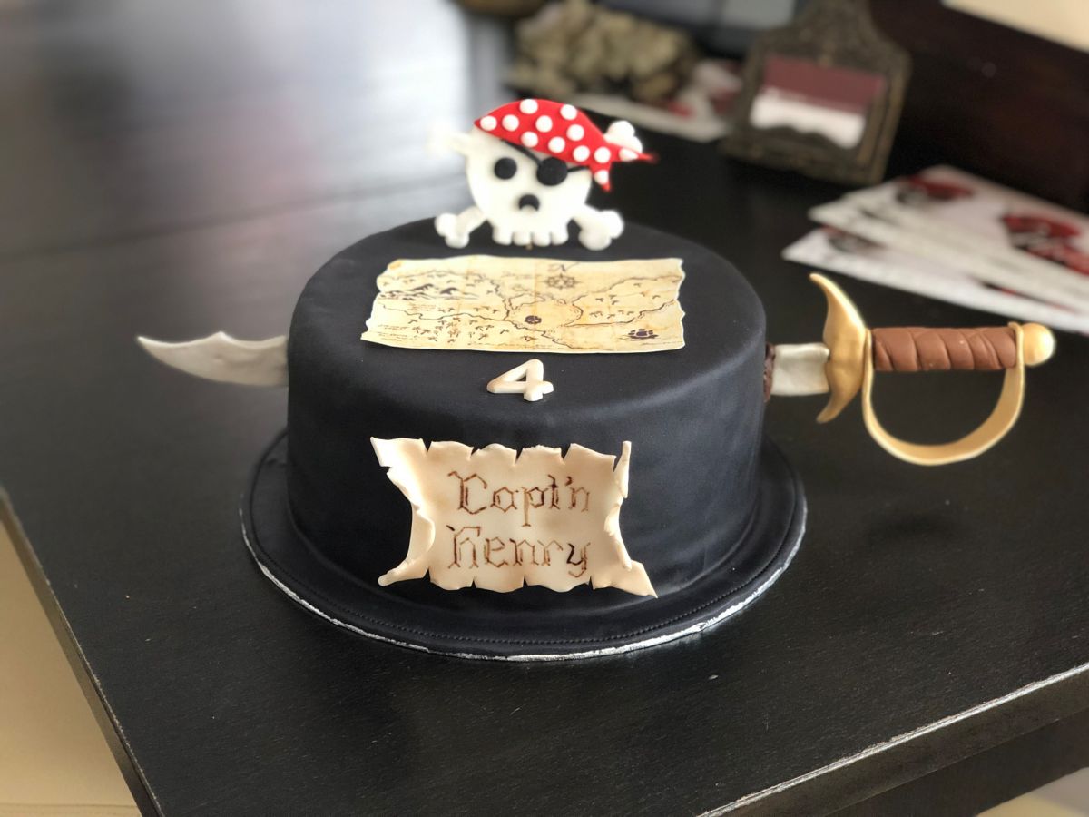 Pirate-themed children’s birthday cake with black fondant, skull and treasure map