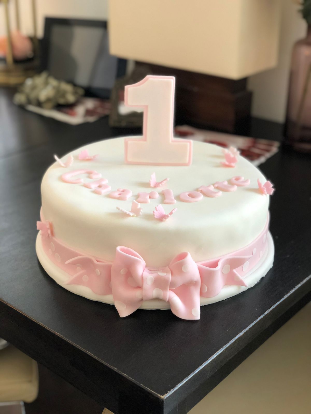 Single-tier white and pink birthday cake with ruffle ribbon bow