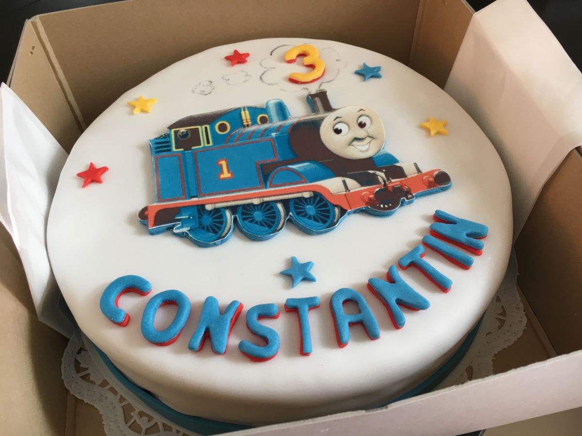 Children’s birthday cake with Thomas the Tank Engine locomotive, blue with stars