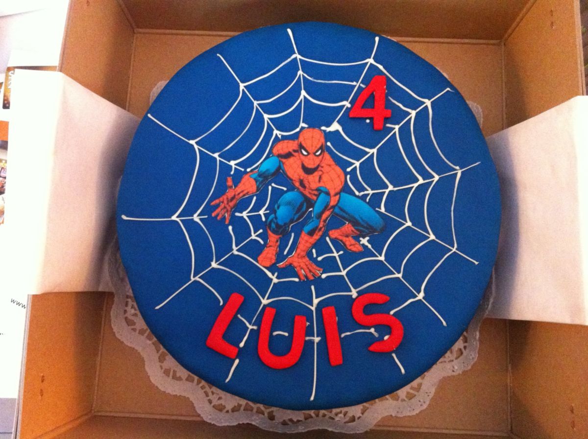 Children’s birthday cake with Spider-Man figure on blue fondant with white web design and name in red letters