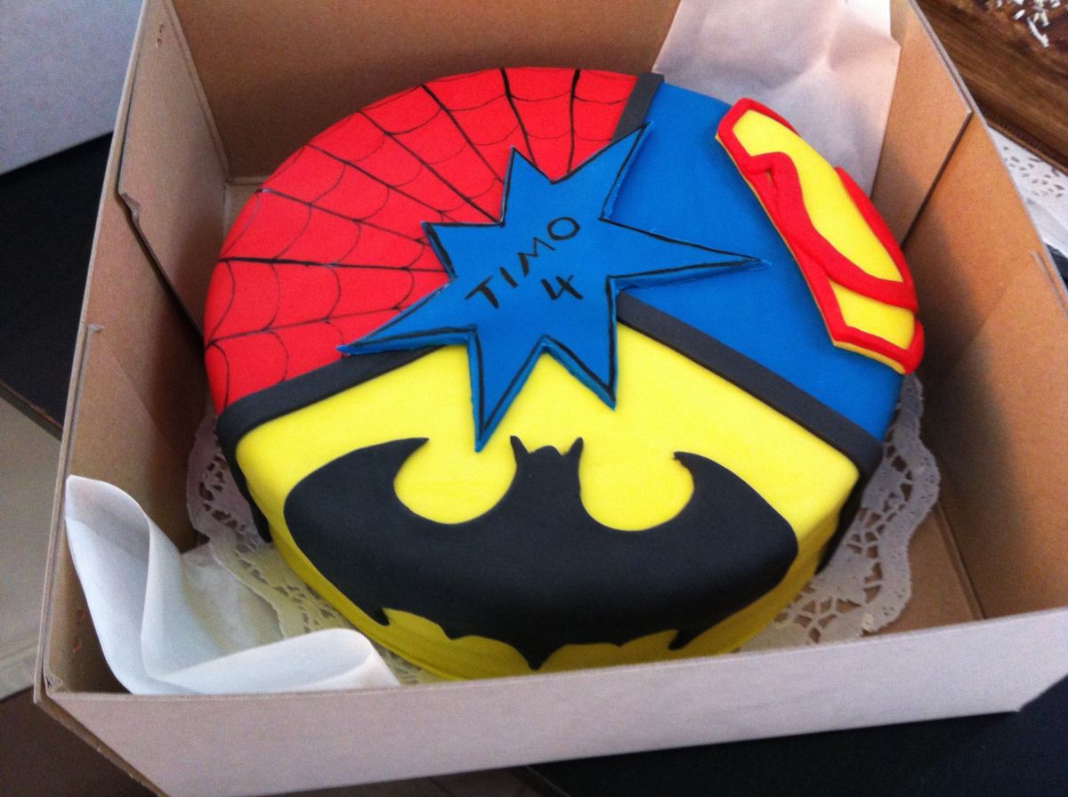 Children’s birthday cake split between Superman and Spider-Man superhero faces