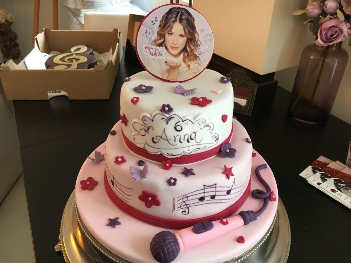 Three-tier pink birthday cake with portrait medallion, sugar flowers and music notes