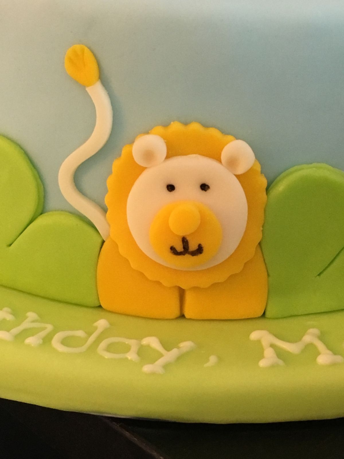 Children’s birthday cake modelled as lion in orange and cream with large ears