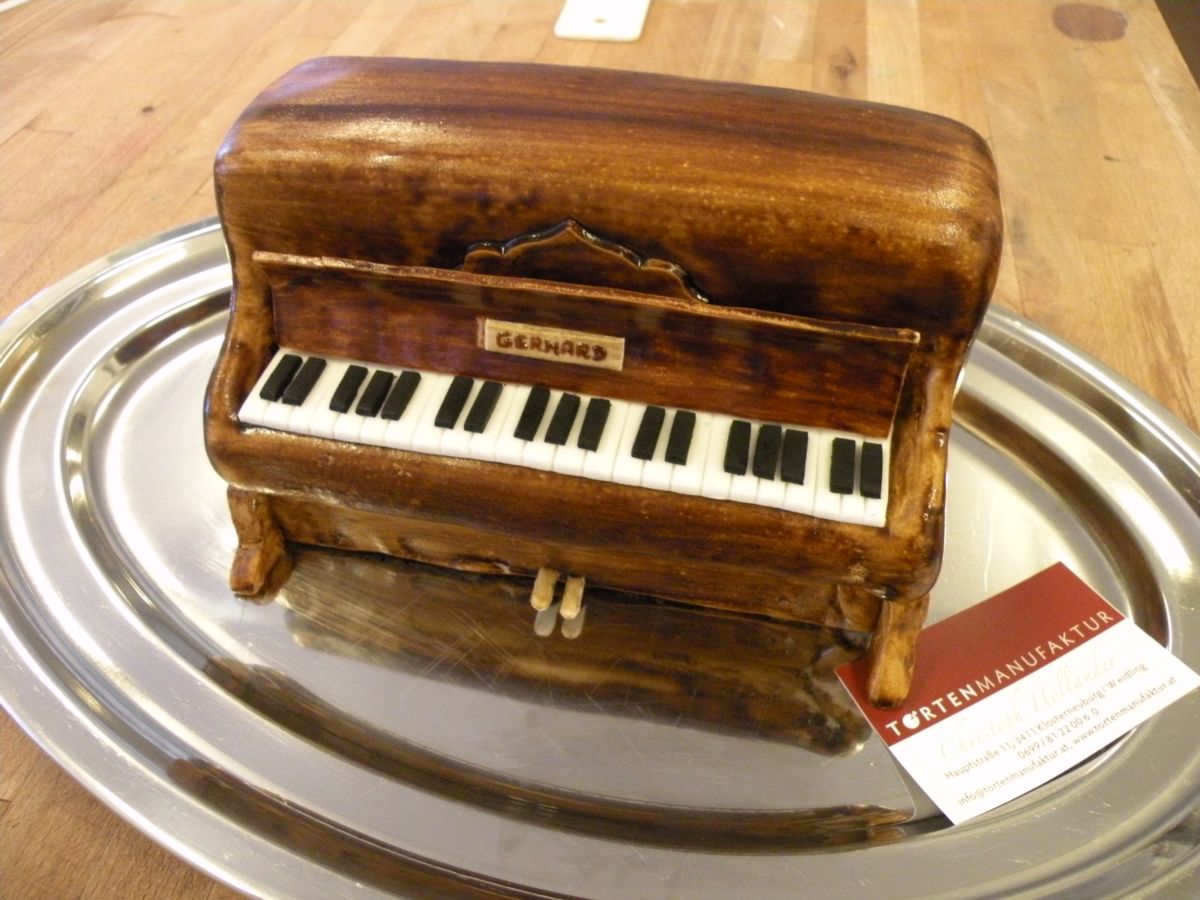 Compact upright piano cake with brown fondant and white keyboard