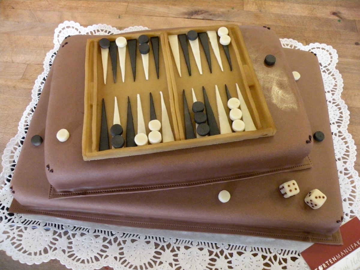 Two-tier backgammon board cake with black and white game pieces