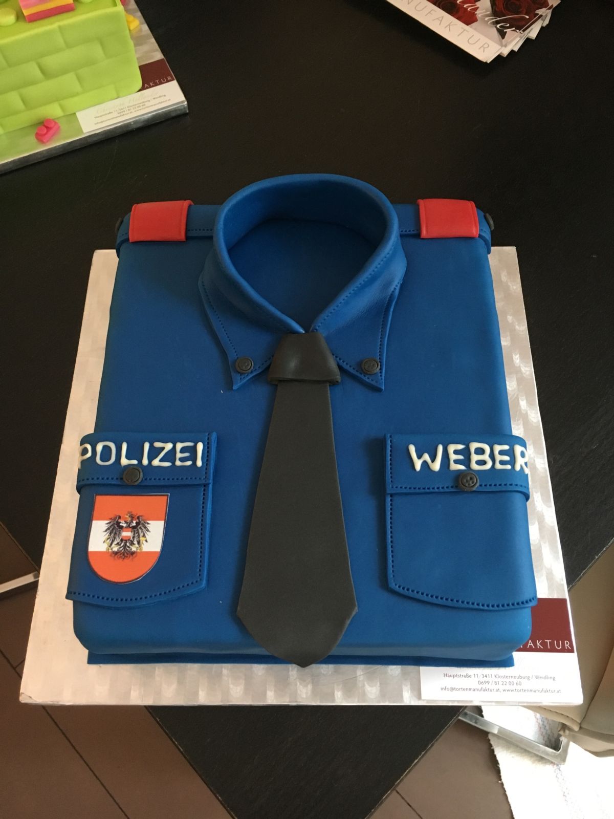 Police uniform cake in blue with red epaulettes and eagle insignia