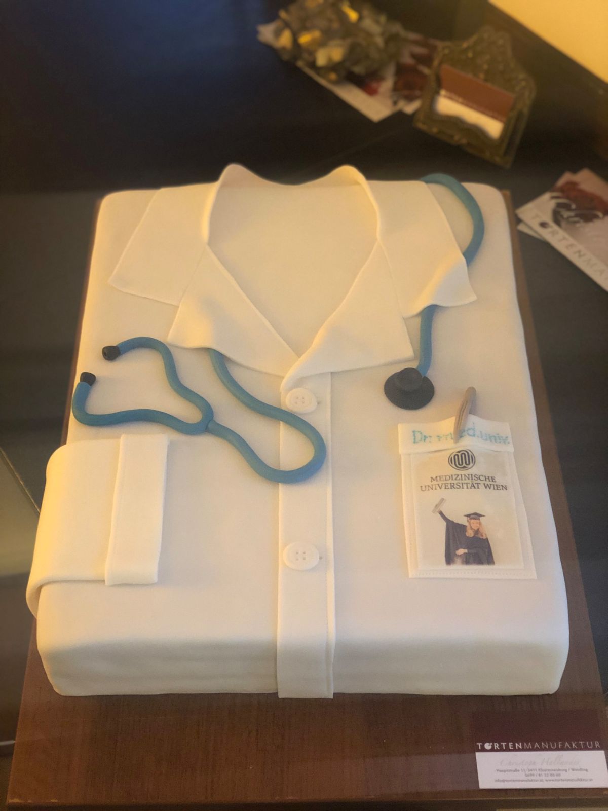 Doctor’s coat cake in white with blue fondant stethoscope