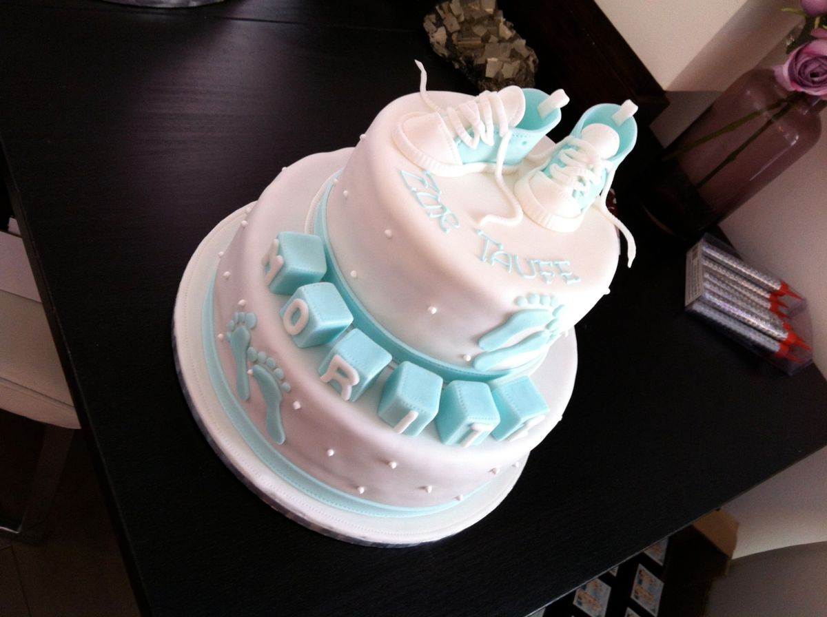 Two-tier christening cake in white and pink with fondant cradle and pearls