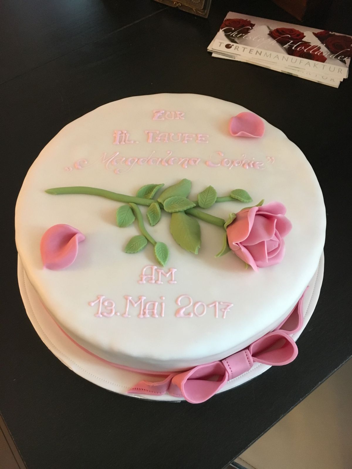 White christening cake with single pink sugar rose and flower border