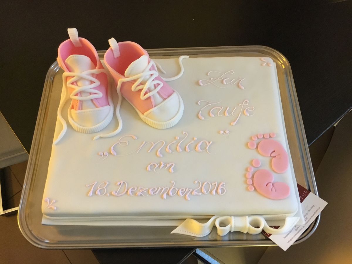 Rectangular christening cake decorated with modelled pink baby shoes