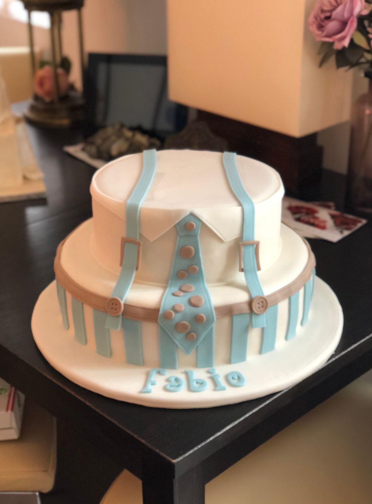 Two-tier christening cake with blue tie pattern and polka dots
