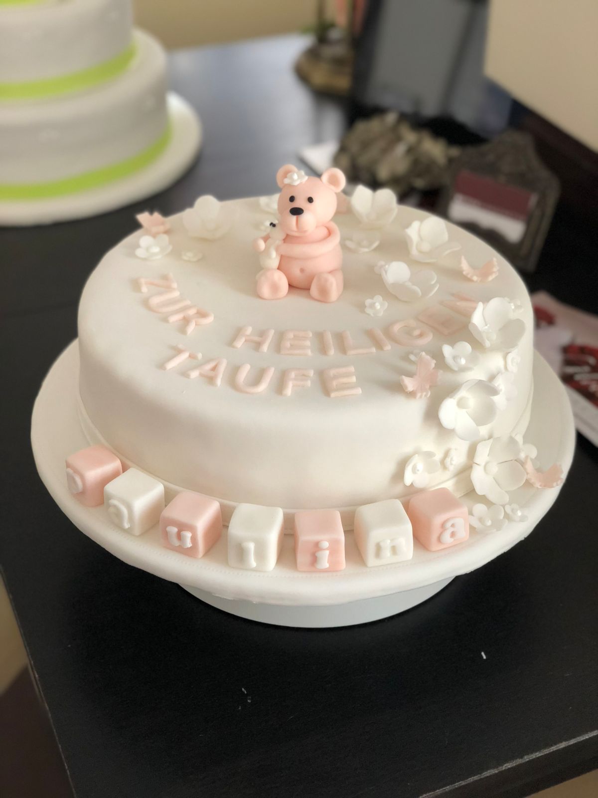 White christening cake with teddy bear and sugar flower garland