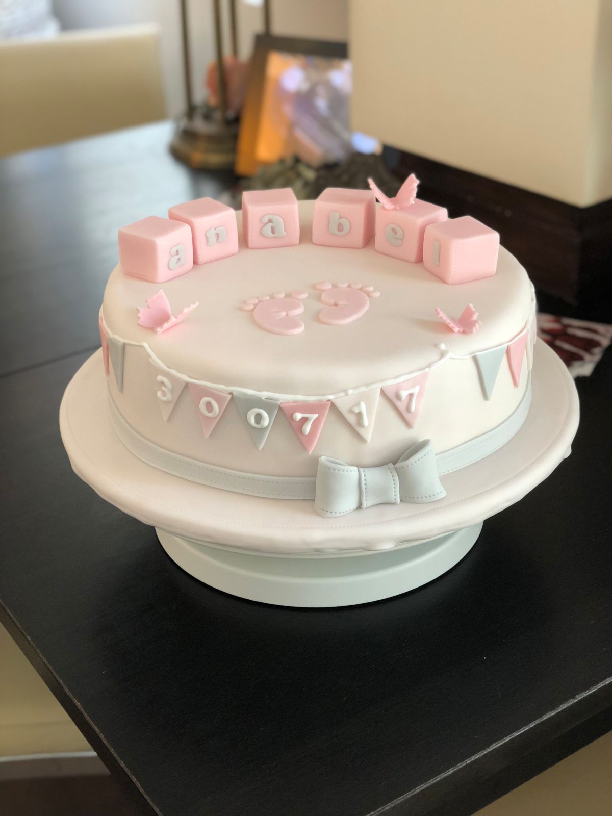 Christening cake with name blocks, bunting and pink bow accent