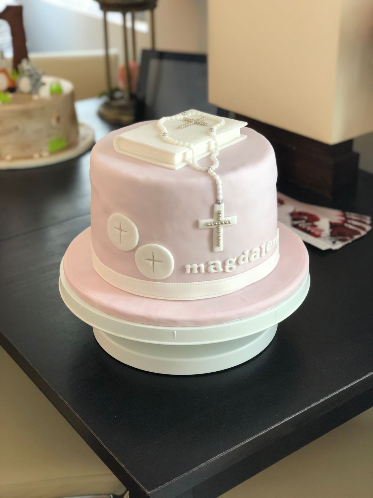 Two-tier pastel christening cake with cross details and white bow