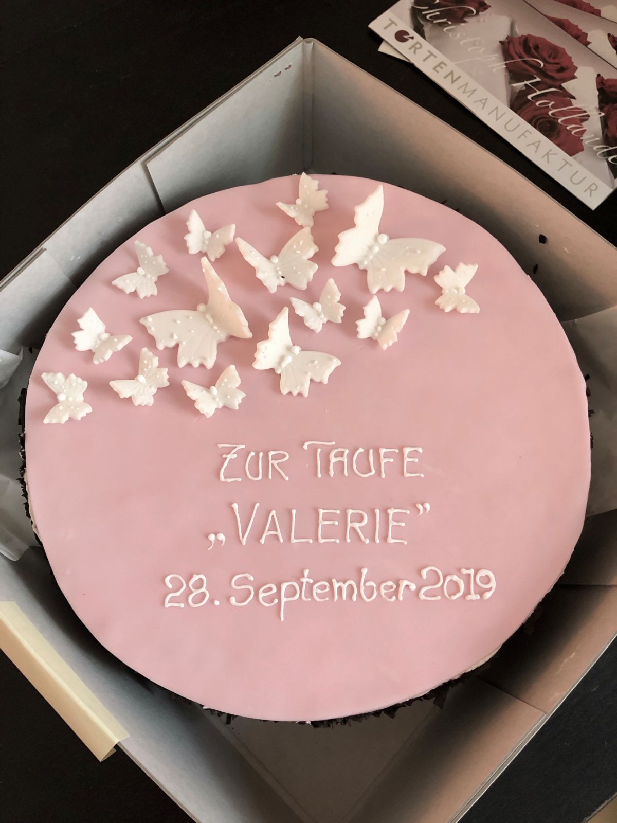 Pink christening cake with white dove decorations